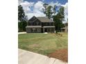 Traditional two-story home with a well-manicured lawn, dark shutters and gray brick at 3030 Fairway Dr, Villa Rica, GA 30180