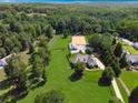 Expansive aerial view of a property featuring a house, horse stables, and a surrounding forest at 206 Savanna Estates Ct, Canton, GA 30115