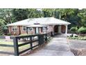 Brick home with a metal roof and a covered carport, showcasing a fenced yard with mature landscaping at 2225 Harold Se Ln, Smyrna, GA 30080