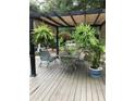 Seating area under covered patio with hanging ferns and a dining table, perfect for outdoor relaxation at 2225 Harold Se Ln, Smyrna, GA 30080