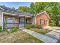 Inviting home with a cozy front porch, brick details, and well-manicured landscaping at 3706 Bouldercrest Rd, Ellenwood, GA 30294