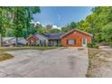 Attractive single-story home with brick accents, mature trees, and a spacious concrete driveway at 3706 Bouldercrest Rd, Ellenwood, GA 30294