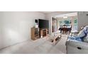 Cozy living room with plush carpet, television, and an adjacent dining space at 735 Wood Valley Trce, Roswell, GA 30076