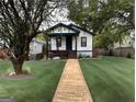 Inviting single-Gathering home with manicured lawn and walkway, showcasing curb appeal and mature trees at 819 Humphries St, Atlanta, GA 30310