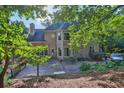 The backyard featuring a wooden deck, mature trees, and well-maintained landscaping at 3875 Sweetwater Dr, Cumming, GA 30041