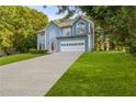 Charming two-story home with blue siding, an attached garage, and a well-manicured front lawn at 1901 Cherwell Dr, Riverdale, GA 30296