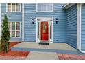 Eye-catching red front door with sidelights and decorative glass panel, complemented by modern lighting at 1901 Cherwell Dr, Riverdale, GA 30296