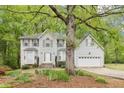 Traditional two-story home with light siding, attached garage, and manicured landscaping at 6230 Lillie Ln, Cumming, GA 30040