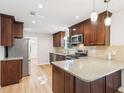 Modern kitchen featuring stainless steel appliances, wood cabinets, and a breakfast bar at 6230 Lillie Ln, Cumming, GA 30040