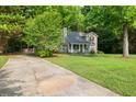 Quaint home with a long driveway and lush greenery offers a serene setting at 135 Dunwick Ln, Mcdonough, GA 30253