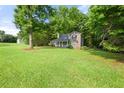 Beautifully landscaped front yard showcases a charming home nestled among mature trees at 135 Dunwick Ln, Mcdonough, GA 30253