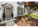 Elegant front entrance features a classic door, beautiful landscaping, and a bay window at 144 Nocatee Trl, Woodstock, GA 30188