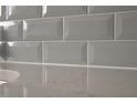 Close-up of gray subway tile backsplash with granite countertops at 1670 Gunnin Nw Trce # 256, Atlanta, GA 30318