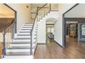 Inviting foyer with hardwood floors, a staircase, and views into the living spaces, with dark trim at 2260 Cobble Creek Ln, Grayson, GA 30017