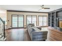 Cozy living room featuring hardwood floors, large windows, built-in shelving, and neutral decor at 2260 Cobble Creek Ln, Grayson, GA 30017