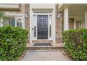 Front door with stone facade and sidelights flanked by manicured bushes for added curb appeal at 4096 Vinings Mill Se Trl, Smyrna, GA 30080