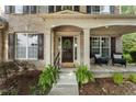 Inviting front porch with seating, decorative wreath on door, and lush landscaping creating a welcoming entrance at 5828 Paliser Trce, Sugar Hill, GA 30518