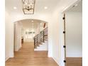 Bright hallway with hardwood floors, modern railing, and an arched doorway leading to other rooms at 219 Poplar Nw St, Lilburn, GA 30047