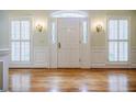 Elegant foyer with hardwood floors, white door and trim, and sidelight windows at 3030 Spalding Dr, Sandy Springs, GA 30350