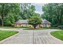 Charming brick home with a circular driveway and mature trees around the well-manicured lawn at 3030 Spalding Dr, Sandy Springs, GA 30350