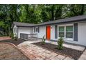 Inviting brick-paved walkway leads to a charming front porch and the bright orange front door of the freshly painted home at 5640 Redan Cir, Stone Mountain, GA 30088
