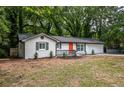 Newly renovated home with a well-manicured front yard and a bright orange front door at 5640 Redan Cir, Stone Mountain, GA 30088