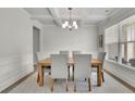 Elegant dining room with coffered ceiling, stylish chandelier, and natural light at 783 Phil Haven Ln, Kennesaw, GA 30152