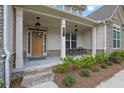 Inviting front porch with seating, stone steps, and stylish lighting at front door entrance at 783 Phil Haven Ln, Kennesaw, GA 30152