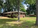 Charming brick home with a well-maintained front yard and mature trees at 4925 Sugar Valley Sw Rd, Mableton, GA 30126