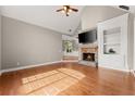Bright living area with stone fireplace, vaulted ceilings, and gleaming hardwood floors at 7615 Abbey Glen Dr, Cumming, GA 30028