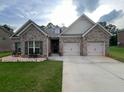 Charming brick home with well-manicured lawn and a two-car garage, providing a welcoming curb appeal at 1128 Carillon Dr, Conyers, GA 30013