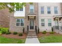 Inviting townhouse entrance with brick facade, stylish door, and manicured landscaping at 3195 Bartee Walk, Suwanee, GA 30024