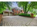 Paver driveway leads to a brick home with an attached garage, offering ample parking and classic charm at 663 Clifton Ne Rd, Atlanta, GA 30307