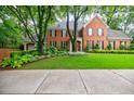 Well maintained lawn and meticulous landscaping frame a brick home with black shutters, exuding timeless elegance at 663 Clifton Ne Rd, Atlanta, GA 30307