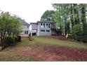 The backyard has a small deck, trees, and a swing set for fun activities at 168 Harmony Grove Rd, Lilburn, GA 30047