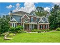 Charming two-story home featuring a lush green lawn and beautifully landscaped front yard at 2637 Morningside Nw Trl, Kennesaw, GA 30144