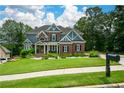 Inviting two-story home featuring a lush green lawn, manicured garden beds, and a welcoming front porch at 2637 Morningside Nw Trl, Kennesaw, GA 30144