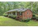 Brick home side view with mature landscaping, showcasing the length of the covered front porch at 286 Hilton Way Way, Canton, GA 30114