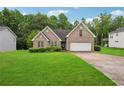Charming brick home with a well-manicured lawn and a two-car garage at 605 Pebble Blvd, Covington, GA 30016