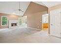 Bright living room with a fireplace, vaulted ceiling, and views of the kitchen at 605 Pebble Blvd, Covington, GA 30016