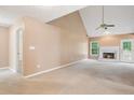 Spacious living room featuring a vaulted ceiling, fireplace, and lots of natural light at 605 Pebble Blvd, Covington, GA 30016