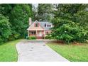 Charming home with a welcoming front porch and long driveway surrounded by lush trees at 3135 Washington Rd, Atlanta, GA 30344