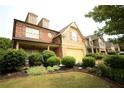 Attractive two-story home with brick and siding facade, complemented by lush landscaping at 560 Tuscany Walk Ln, Lawrenceville, GA 30043