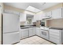 Bright kitchen featuring white cabinetry, appliances, and a view to the back yard at 2135 Knighton Dr, Atlanta, GA 30349