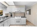 Kitchen featuring white cabinetry and a view to the adjacent sun room and dining area at 2135 Knighton Dr, Atlanta, GA 30349