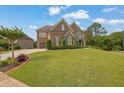 Beautiful two-story brick home on a landscaped lawn with a symmetrical layout and a charming driveway at 2450 Weber Heights Way, Buford, GA 30519