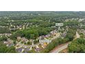 Aerial view of a home with pool and tennis court, nestled in a neighborhood with mature trees and lush greenery at 4434 Austin Hills Dr, Suwanee, GA 30024