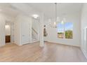 Bright, open-concept living space with wood floors and elegant chandelier at 727 Crest Line Trl, Powder Springs, GA 30127