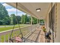 Covered front porch boasts a swing and wood flooring, perfect for relaxing outdoors at 19 Quail Hollow Ct, Dallas, GA 30157