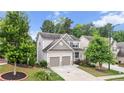 View of home showcasing two-car garage, tidy lawn and landscaping, in a tree-filled neighborhood at 2013 Chesley Dr, Austell, GA 30106
